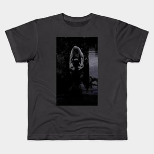 Digital collage, special processing. Strong guy, raised his hands, near big stone. Dark water, mystic. Black and blue, contrast. Kids T-Shirt